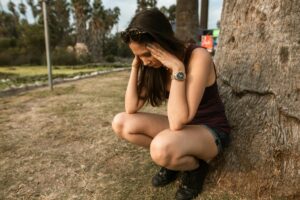 woman kneeled over next to a tree experiencing anxiety. How long does Ativan last.